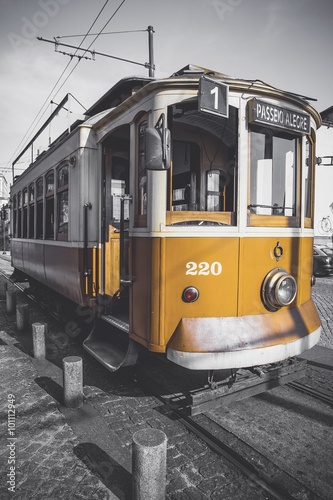 Desaturated picture of the Porto trolley except for its particular yellow.