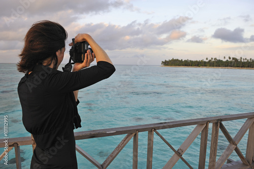 Woman taking a photograph of a tropical island, Borneo, Sabah State, Malaysia, Southeast Asia