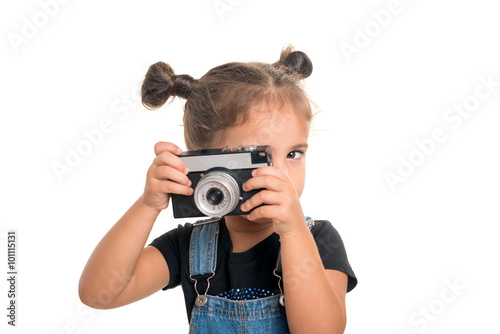 Baby girl with vintage camera posing in studio.Isolated
