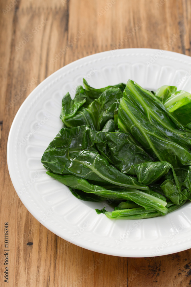 boiled cabbage on white plate on brown wooden background boiled cabbage on white plate on brown wooden background