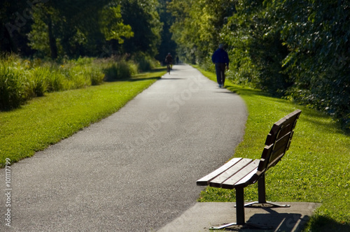 Park Bench and Person on Walking Trail Photo © Pvstockmedia