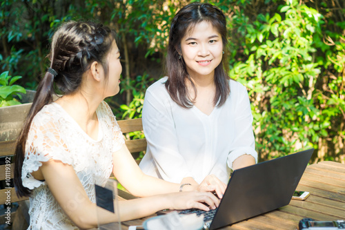 Asian businees women enjoying with her friend on laptop