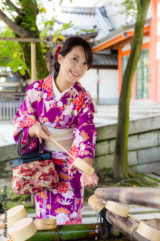 Japanese Woman washing hand before entering the temple Japanese Woman washing hand before entering the temple