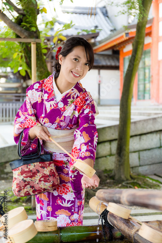 Japanese Woman washing hand before entering the temple