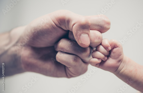 Fist of Dad and Newborn Baby photo