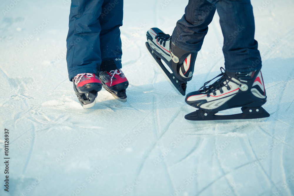 Fototapeta premium father and little son learning to skate in winter snow.