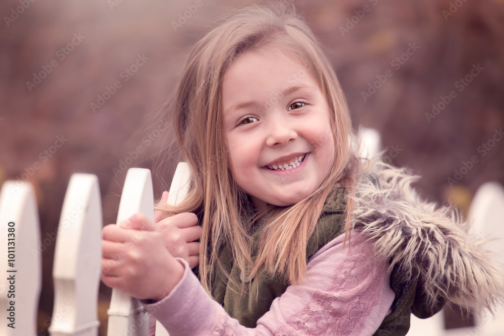 Φωτογραφία artistic outdoor portrait of a cute blond girl holding on to a fence