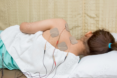 Woman with eletrical stimulator for increase muscle strength and photo