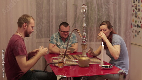 Among friends smoking shisha and playing cards photo