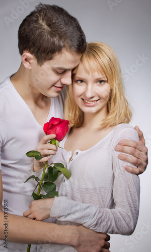 young couple of lovers. Man presents red rose for Valentine day.