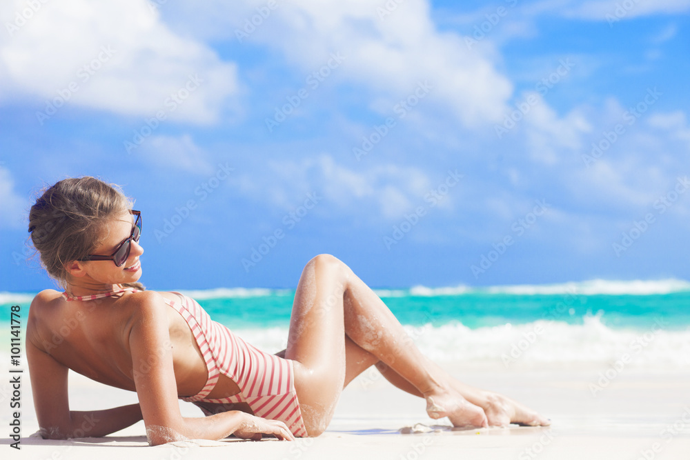 young woman in stripy swimsuit at tropical beach young woman in stripy swimsuit at tropical beach