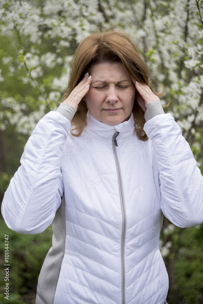 adult woman with headache about bird cherry blossoms in spring adult woman with headache about bird cherry blossoms in spring