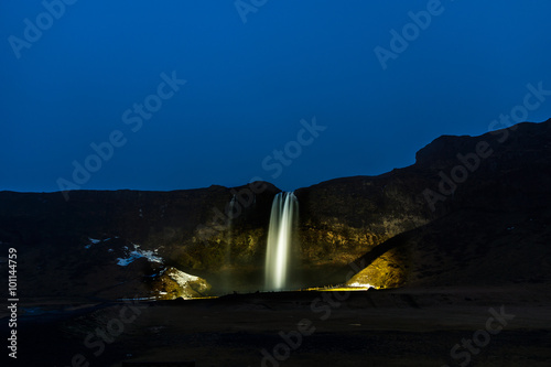 Vászonkép seljalandsfoss waterfall by night lit up by spotlights