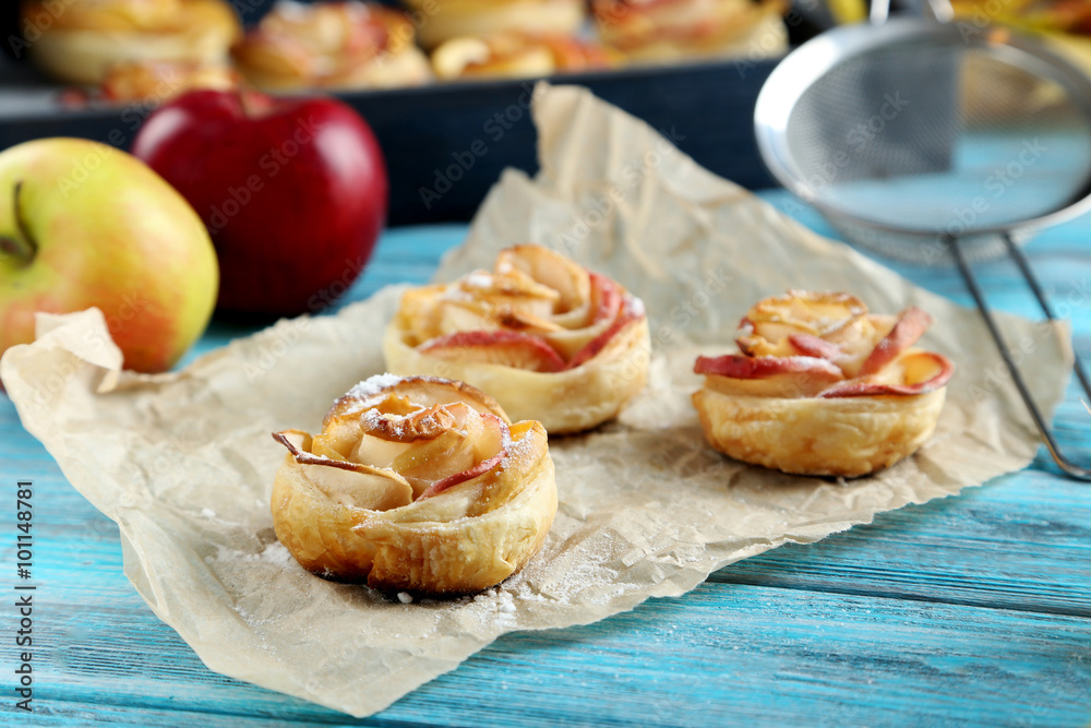 Fresh puff pastry with apple shaped roses on blue wooden table Fresh puff pastry with apple shaped roses on blue wooden table