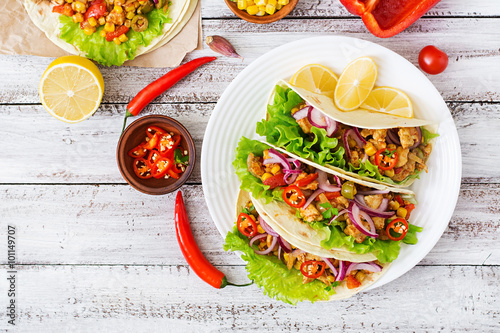 Mexican tacos with meat, corn and olives on wooden background. Top view