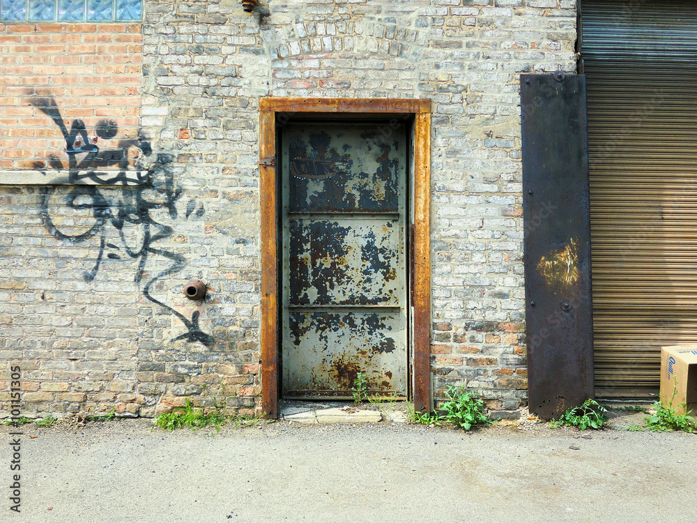 Doorway on brick wall in urban setting with graffiti - landscape photo