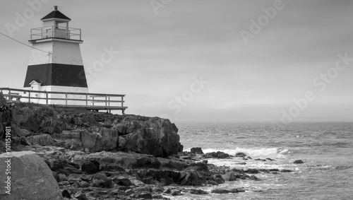 Lighthouse in Margaretsville, Nova Scotia. Overcast spring day in the Bay of Fundy. A lone lighthouse atop an outcropping of rock in the Bay on an grey sky, late spring day in Nova Scotia.