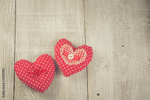 Two hearts hanging on wooden background