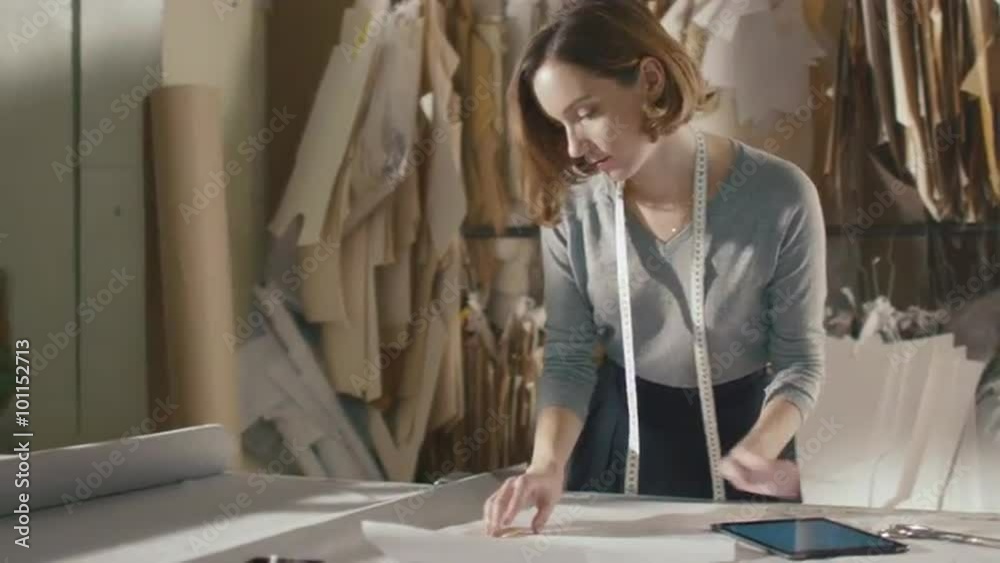 Clothing designer is working with a tablet in a workshop. Shot on RED Cinema Camera.
