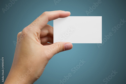 Hand holding white blank business visit card, gift, ticket, pass, present isolated on blue background. Copy space for text. Corporate identity package Template ID