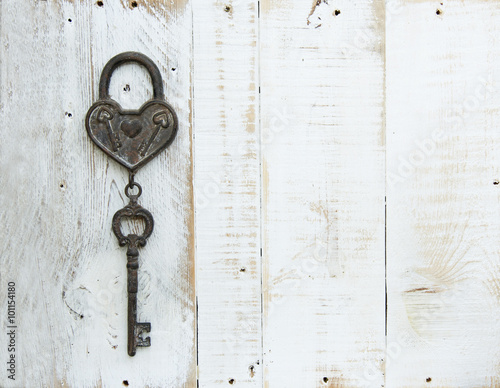 Heart and key on white wooden background