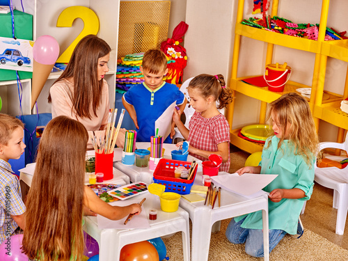 Large group children with teacher woman learn painting on paper  in  preschool . 