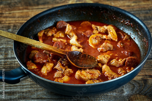 Chicken meat and chorizo cooking in the frying pan