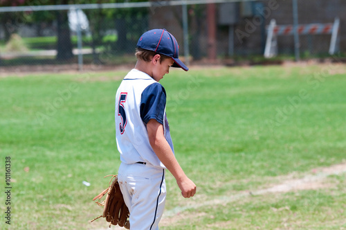 Photography Young american baseball boy looking down on field
