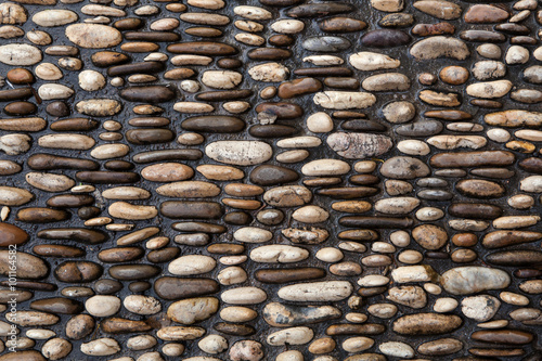 Cobbled pavement made of river rounded pebbles. Background textu