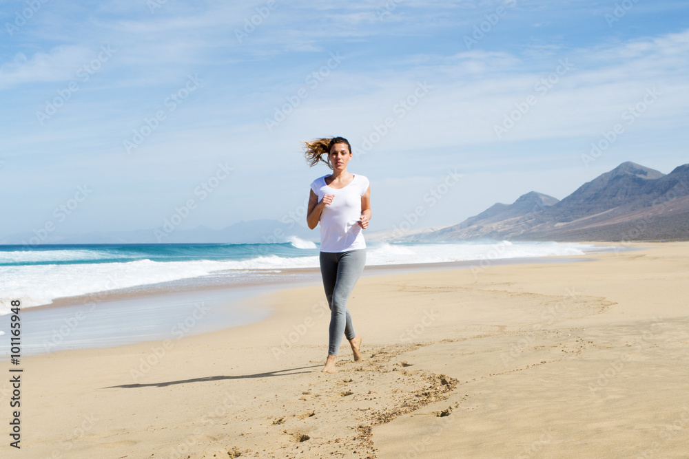 Attraktive Frau joggt am Strand