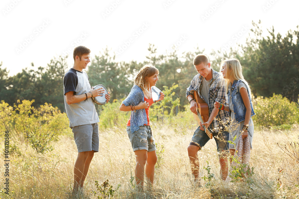 Fototapeta premium Joyful smiling friends dancing in the forest outdoors
