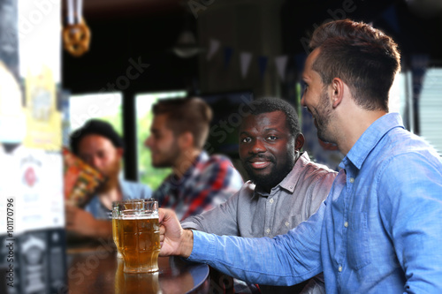 Young men drinking beer in pub