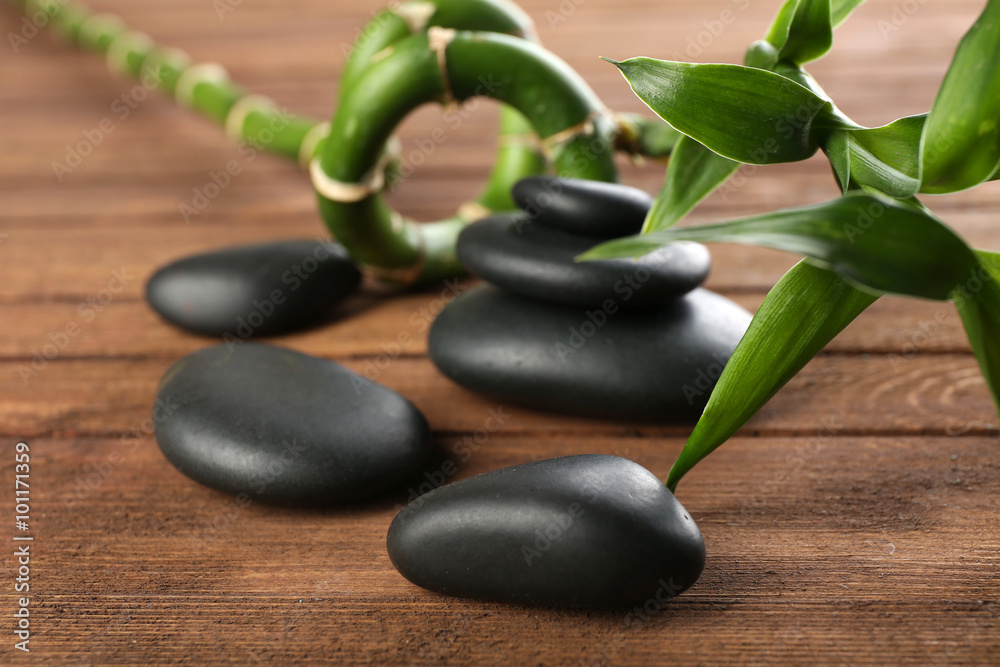 Spa stones and bamboo branch on wooden background Spa stones and bamboo branch on wooden background