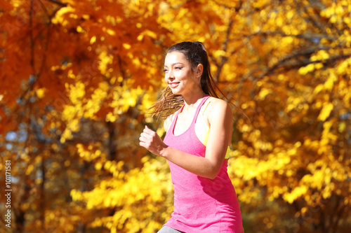 Fototapeta Naklejka Na Ścianę i Meble -  Young beautiful woman jogging in autumn park