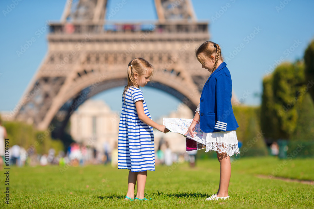 Adorable little girls with map of Paris background the Eiffel tower