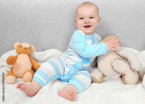 Adorable baby with teddy bears on sofa in the room, close up