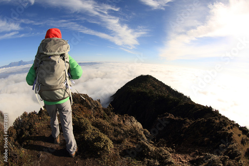 young woman backpacker hiking at mountain peak