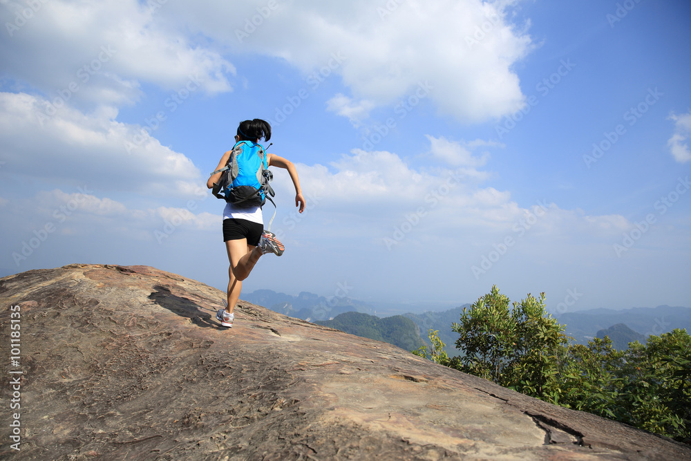 young asian woman hiker running on mountain peak cliff young asian woman hiker running on mountain peak cliff
