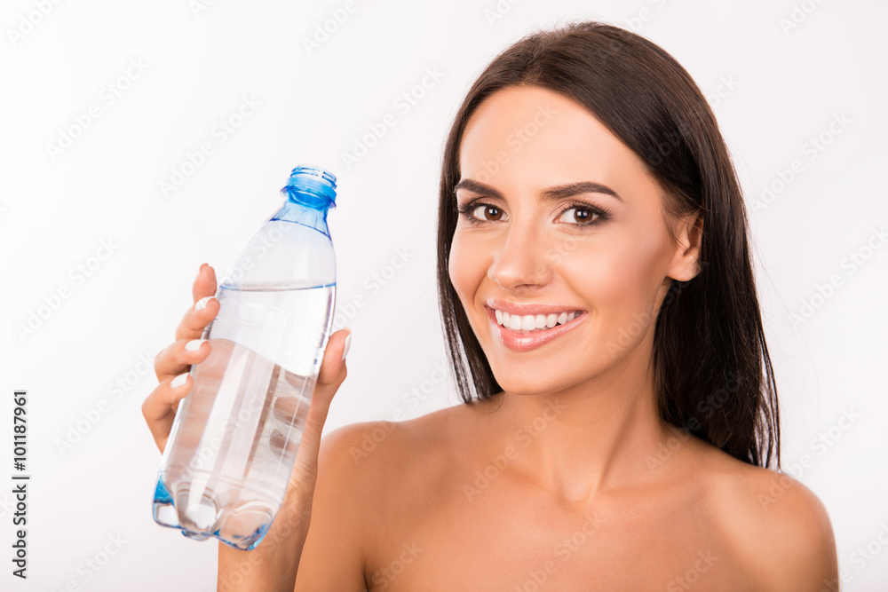Slim cute young girl holding a bottle with water Slim cute young girl holding a bottle with water