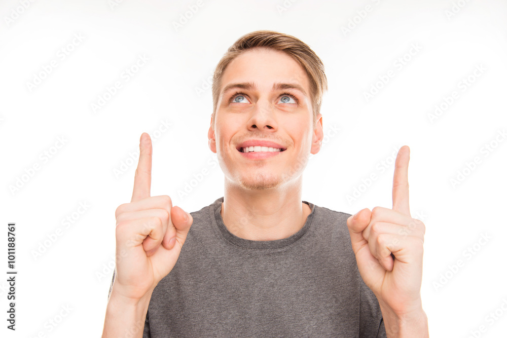 Smilling handsome man gesturing and pointing up