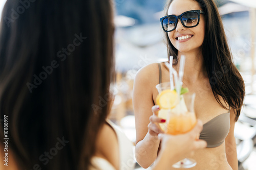 Beautiful women on beach enjoying cocktails