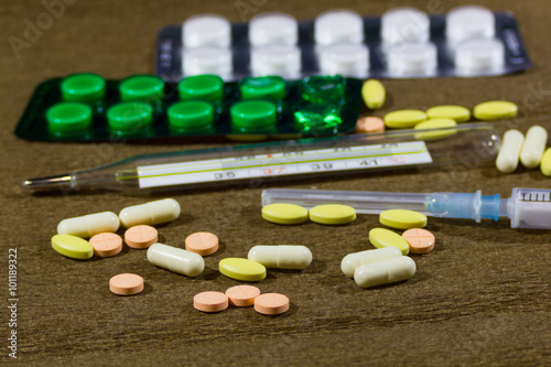 Tablets thermometer and injector on the table