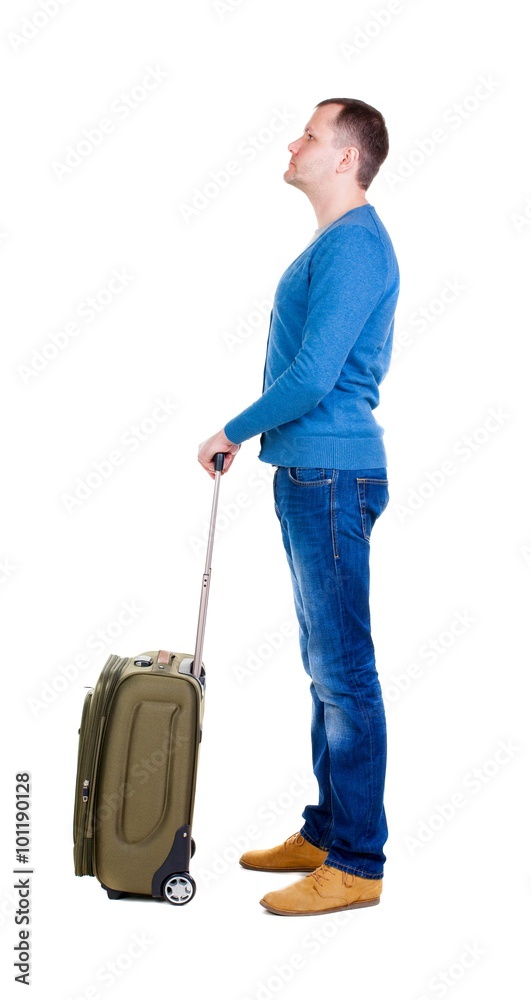 Back view of man with green suitcase looking up. Back view of man with green suitcase looking up.