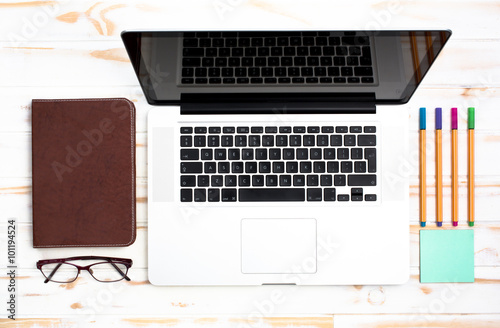 Laptop and stationery objects on a white wooden table
