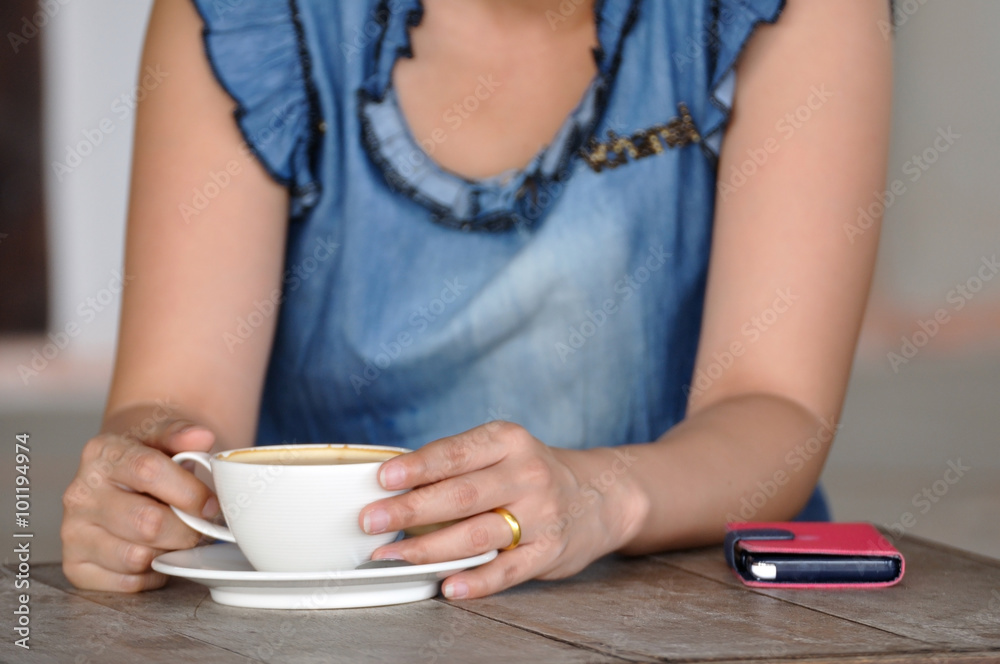 Asian woman relaxing with smartphone and coffee. Asian woman relaxing with smartphone and coffee.