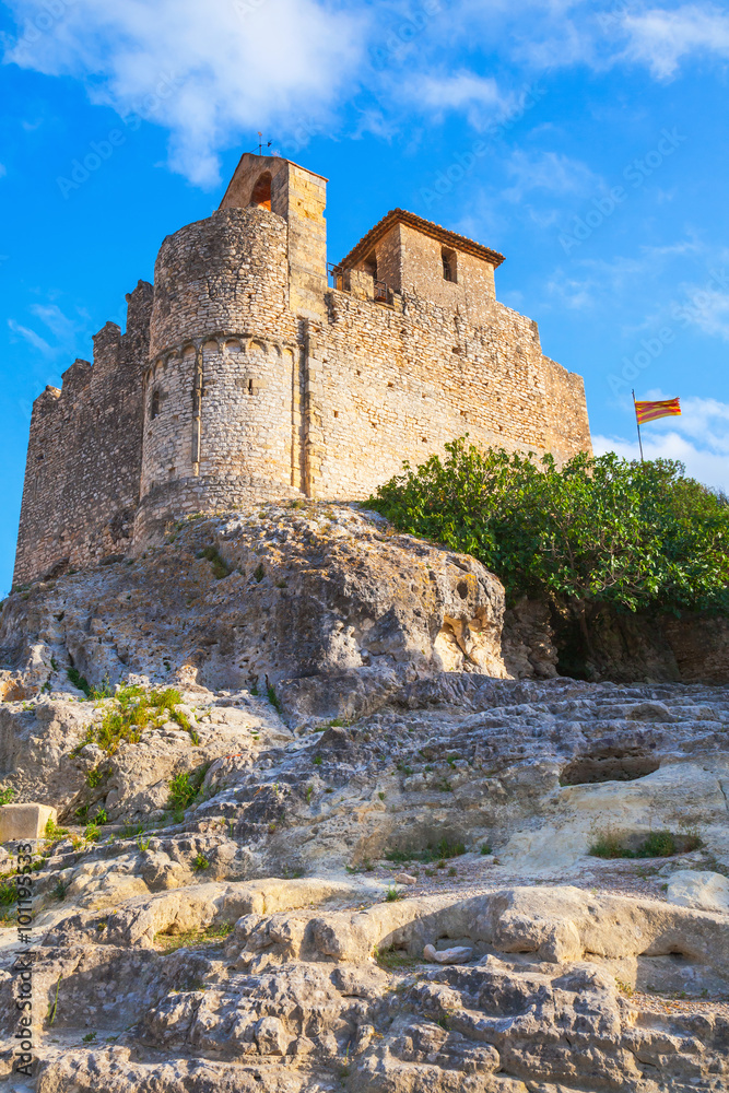 Medieval stone castle and flag of Catalonia