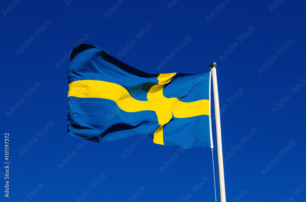 Fototapeta Flag of Sweden against the blue sky, national patriotic background
