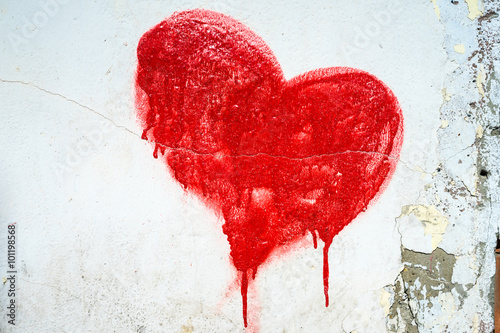 Red painted heart on blue cracked wall