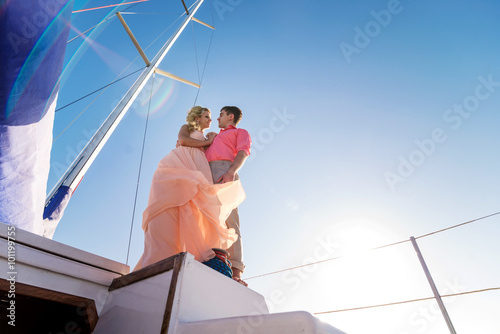Elegant dressed couple riding on a yacht
