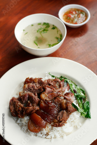 Stewed pork leg on rice with spicy sour sauce and soup